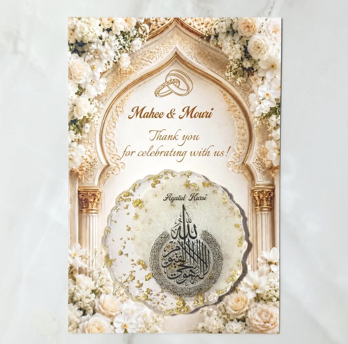 Round resin coaster with Ayatul Kursi in silver, mounted on a floral arch thank-you card for Mahee & Mouri